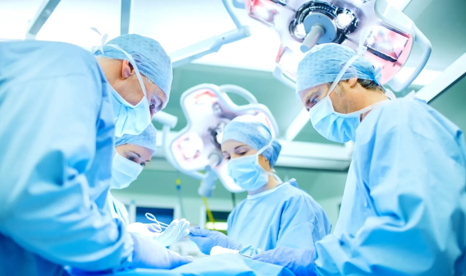 Surgical team at work under operating lights